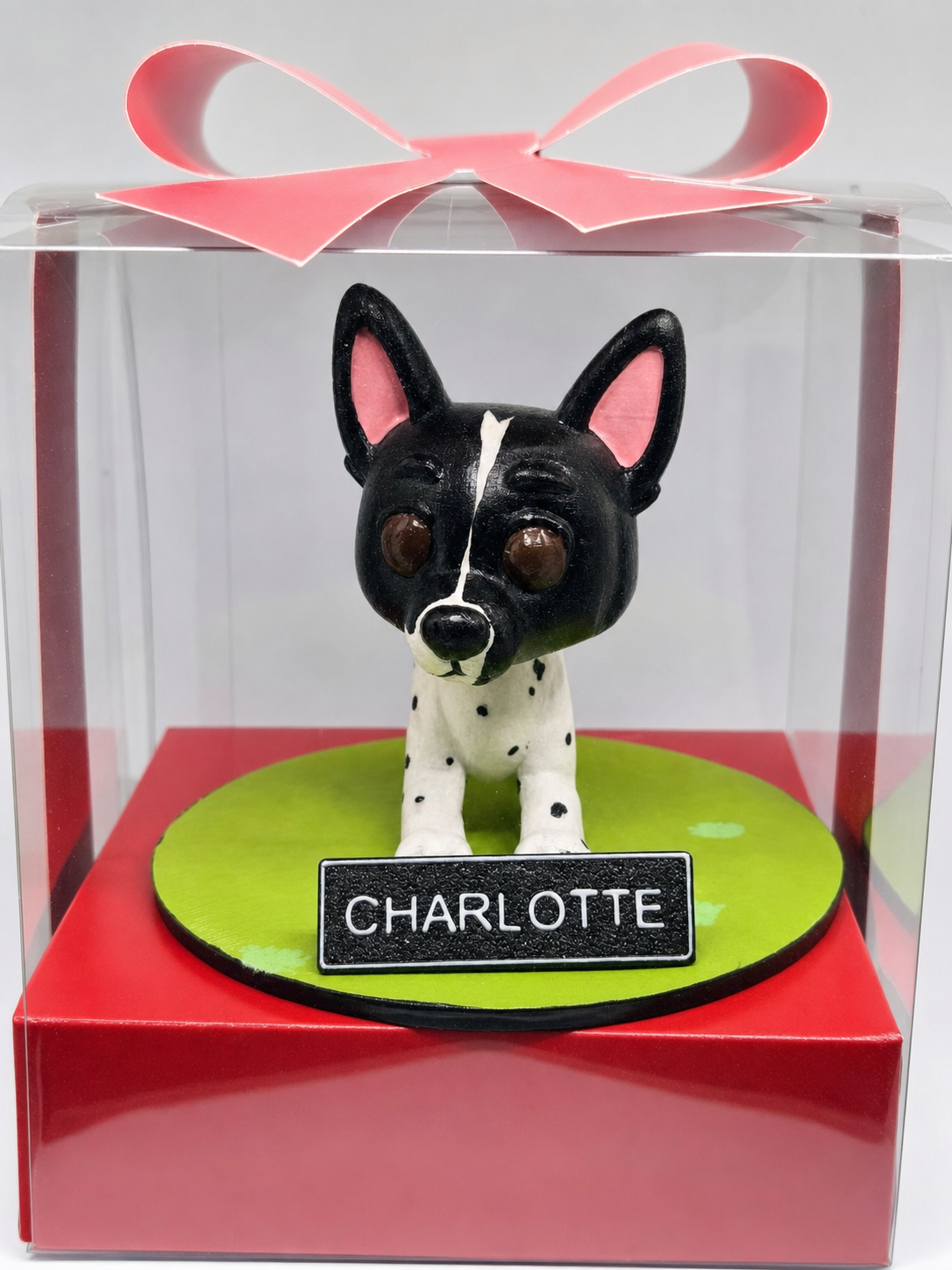 Miniatura de cachorro Charlotte em caixa com laço